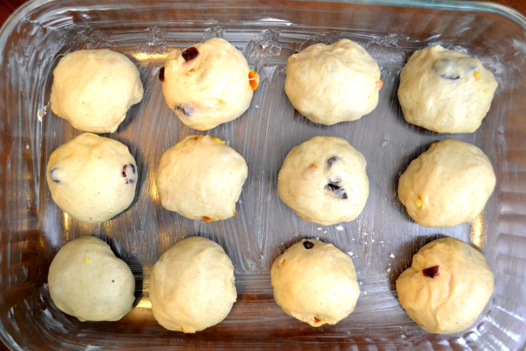 Cranberry Orange Hot Cross Buns dough in ball in buttered baking dish