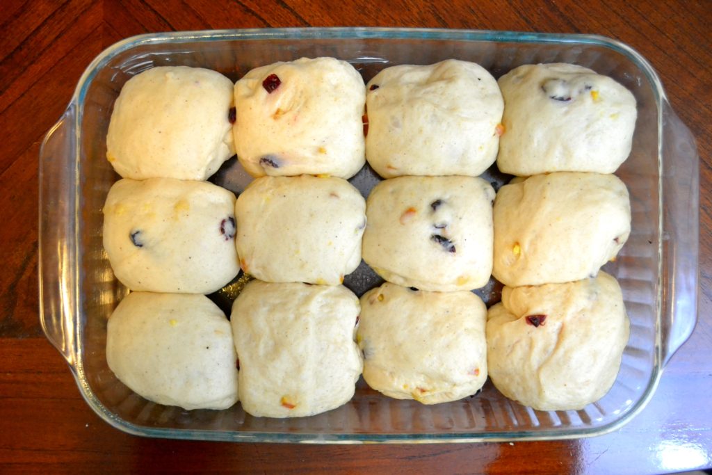 Cranberry Orange Hot Cross Buns dough in balls after rising in baking dish 