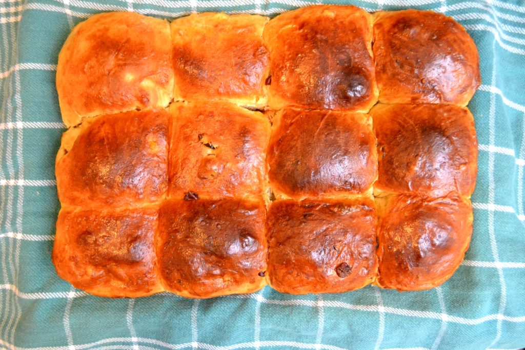 Cranberry Orange Hot Cross Buns after baking on green towel