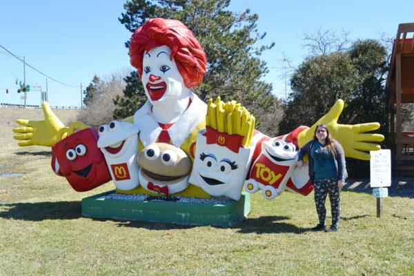 Giant Ronald McDonald Statue with woman standing nearby smiling