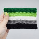 hand holding a crochet aromantic pride flag