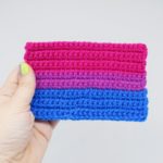 Hand holding a crochet bisexual pride flag