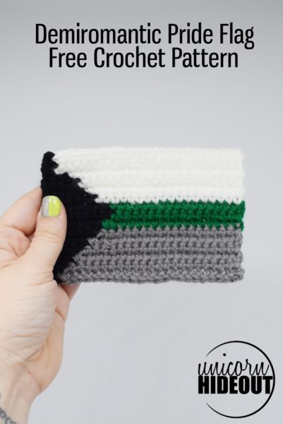 Hand holding a crochet demiromantic pride flag on a white background, word on image: Demiromantic Pride Flag Free Crochet Pattern Unicorn Hideout