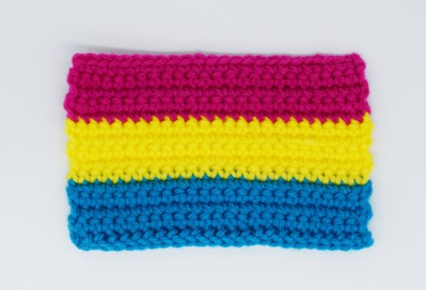 crochet pansexual pride flag against a white background