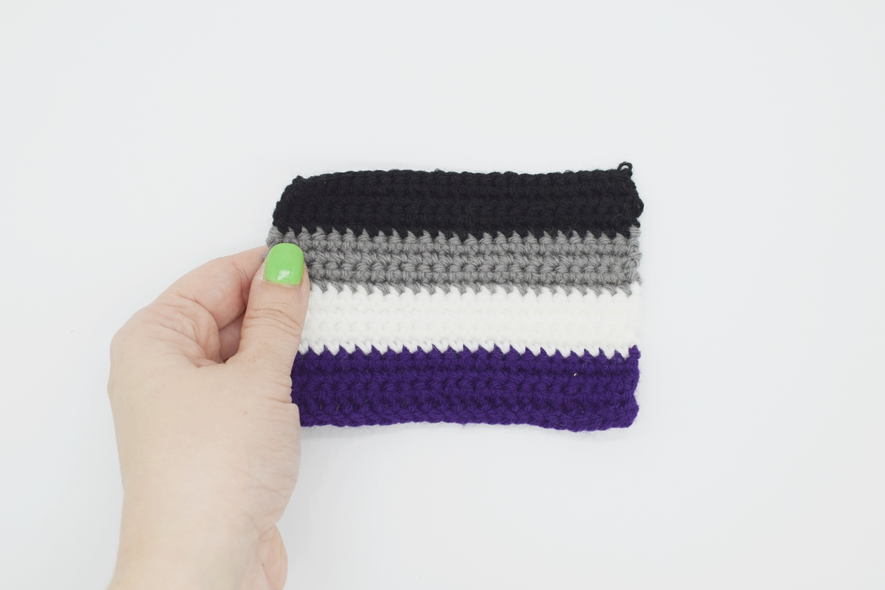 hand holding a crochet asexual pride flag