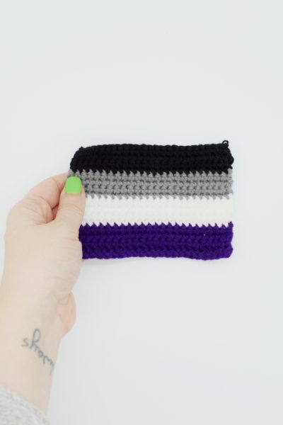 hand holding a crochet asexual pride flag