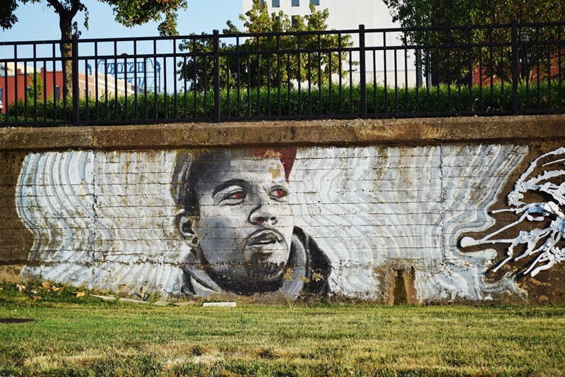 Mural of the portrait of a face on a short brick wall