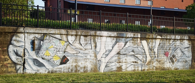 Mural of legs in a bed on a low brick wall