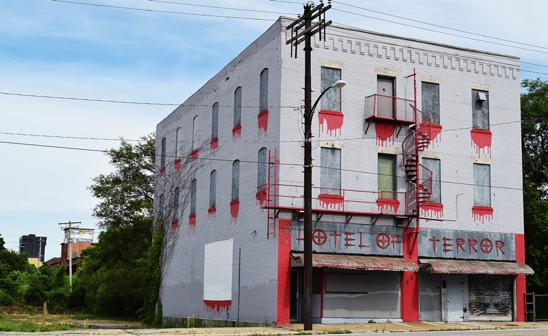 Gray building with blood drips painted on below the windows