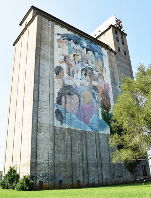 Large mural on the side of an abandoned industrial building