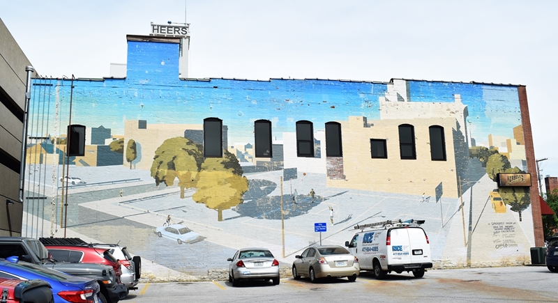 Large two story mural of an street scene at sundown